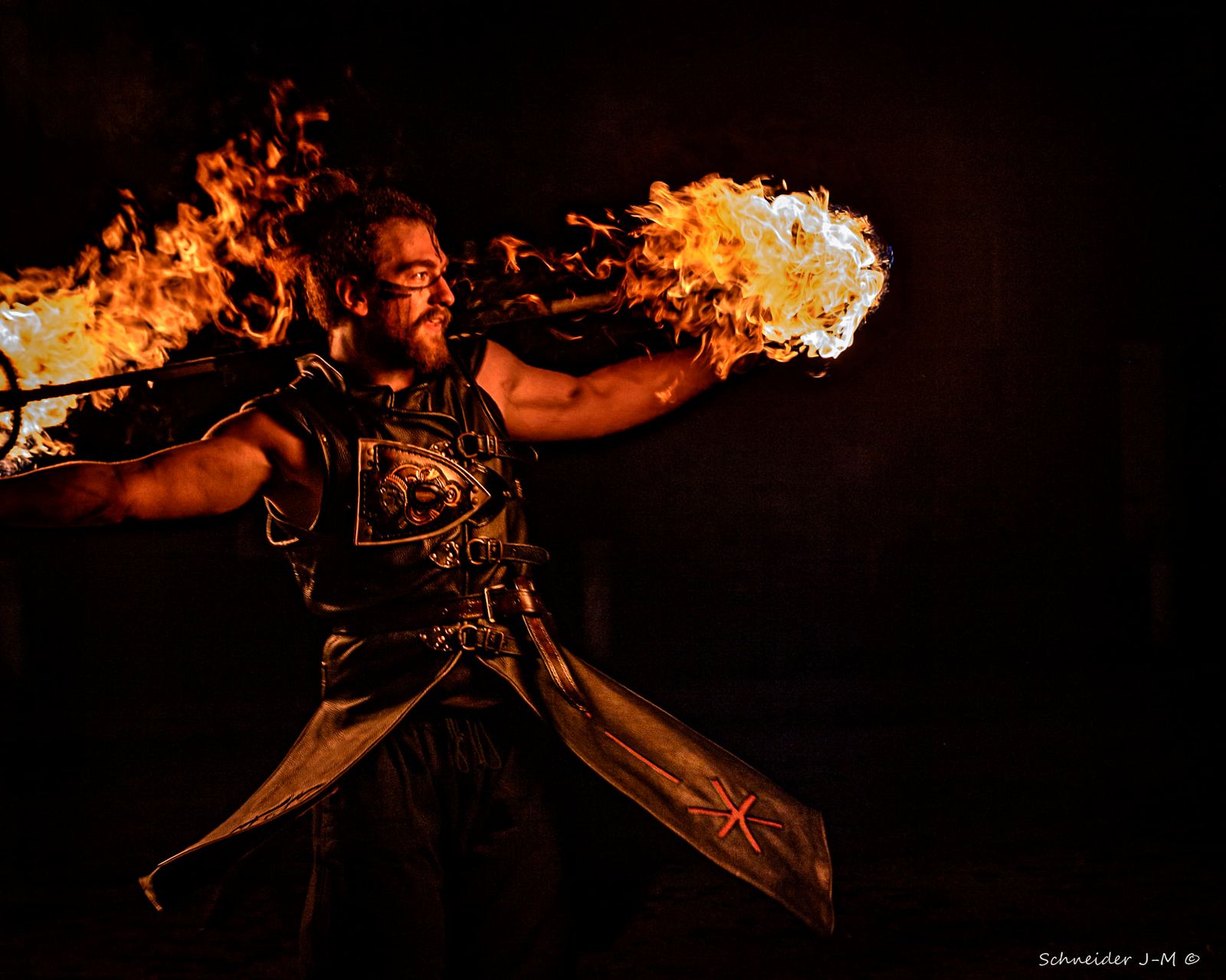 Artiste Pyronix jonglant avec des torches enflammées, spectacle Ragnarök